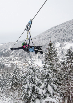 photo prise en hiver avec de la neige d'une personne sur l'activité fantasticable qui ressemble à une tyrolienne