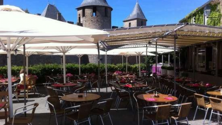 Tables du restaurant du Saint-Jean recouvert par des parasols