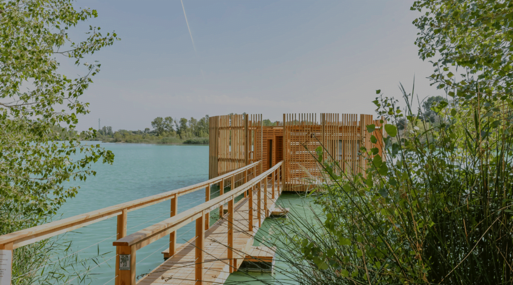 Ponton en bois qui mène à une cabane sur pilotis sur un lac