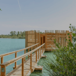 Ponton en bois qui mène à une cabane sur pilotis sur un lac