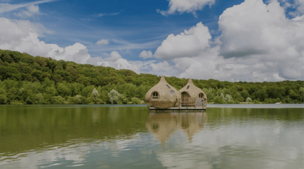 2 cabanes sur pilotis sur un lac entourés d'arbres