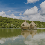 2 cabanes sur pilotis sur un lac entourés d'arbres