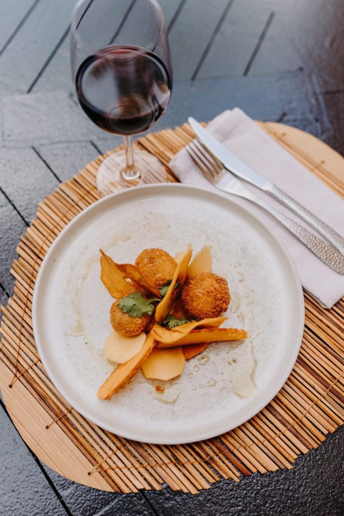 photo d'une assiette avec un met salé, couvert et un verre de vin de rouge