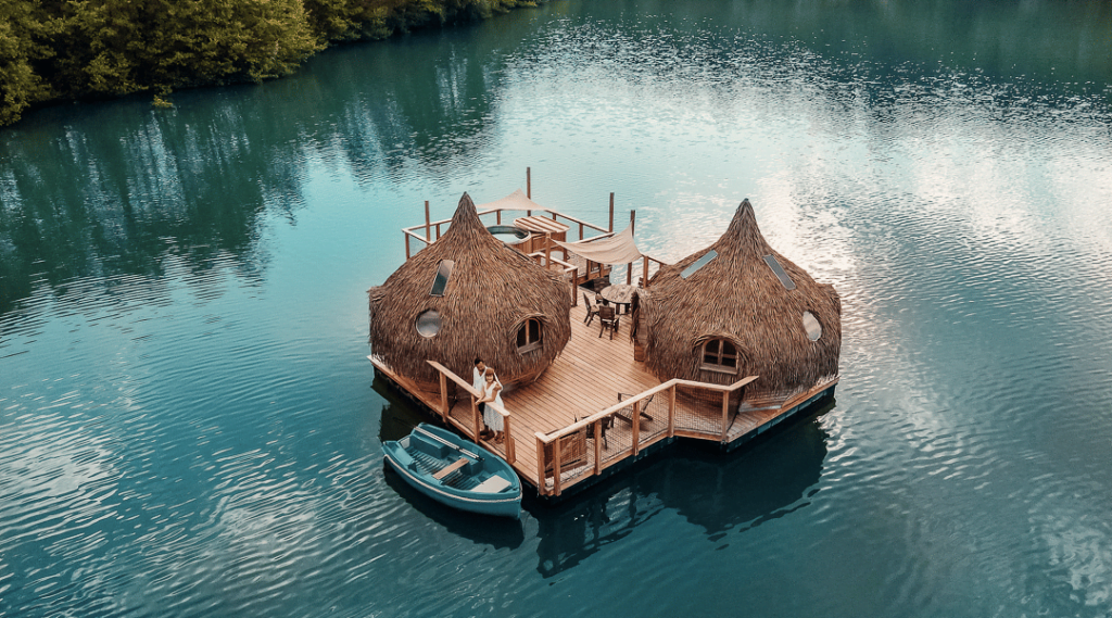 Cabane sur pilotis avec deux personnes et un pirogue sur un lac