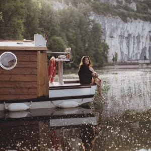 Femme assise sur l'avant d'un bateau-cabane - ma Parenthèse Flottante