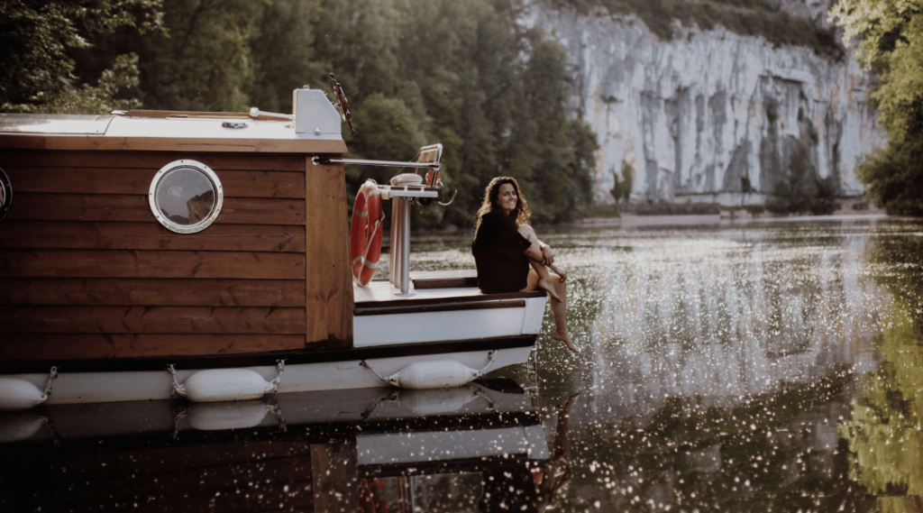 Femme assise sur l'avant d'un bateau-cabane - ma Parenthèse Flottante