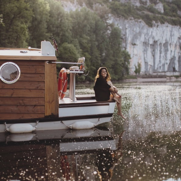 Femme assise sur l'avant d'un bateau-cabane - ma Parenthèse Flottante