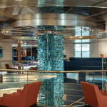 Chaises et tables qui entourent une colone en verre