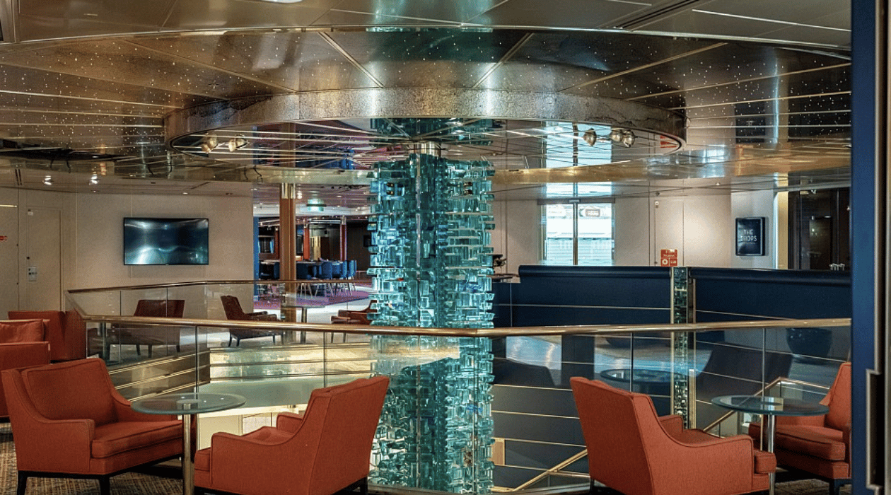 Chaises et tables qui entourent une colone en verre