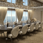 Table avec des couverts, bouteilles de champagne et avec une vue sur la mer à travers des fenêtres