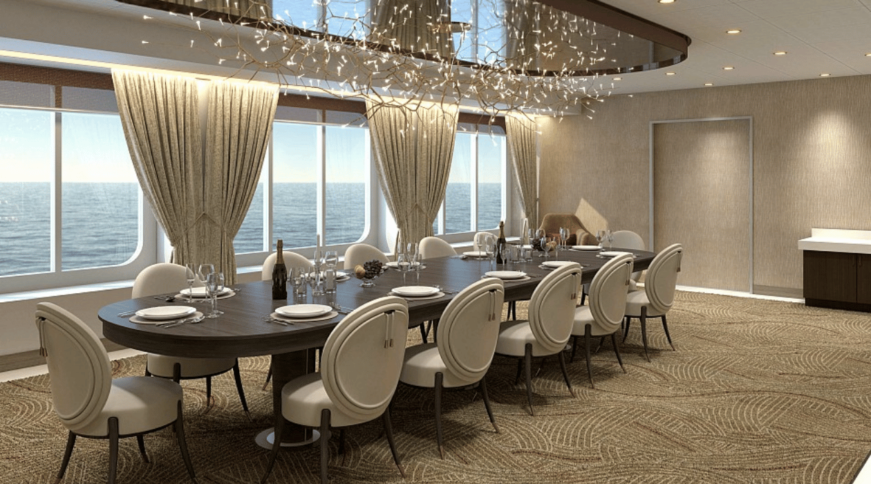 Table avec des couverts, bouteilles de champagne et avec une vue sur la mer à travers des fenêtres