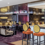 Bar avec des chaises et des projecteurs de lumières au plafond