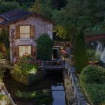 Hôtel Moulin du Roc vue de loin avec la rivière et les lumières allumées
