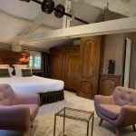 chambre avec lit double accès salle de bains deux fauteuils