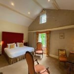 chambre avec lit double fauteuils fenêtres ouvertes