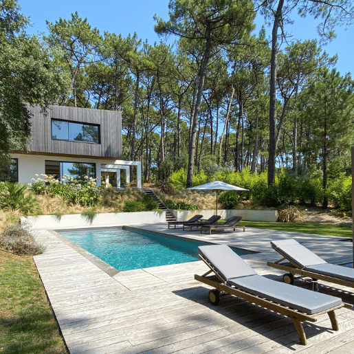 Transat au cord d'une piscine et en fond la villa Landifornia et ses baie vitrées