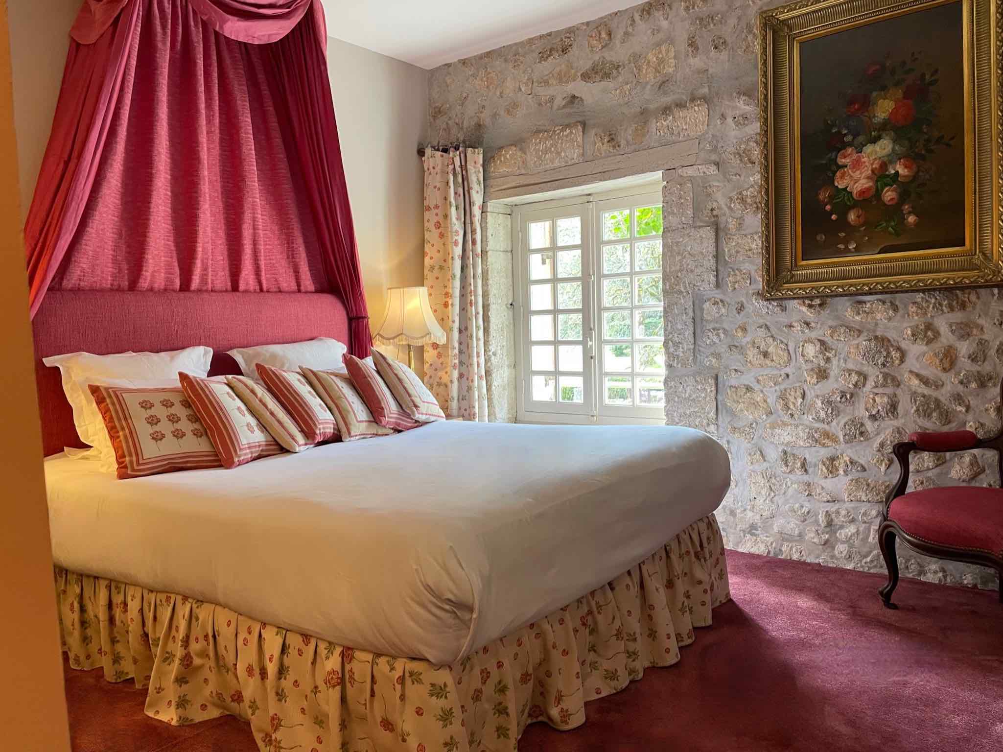 chambre lit double avec fenêtre blanche et moquette rose