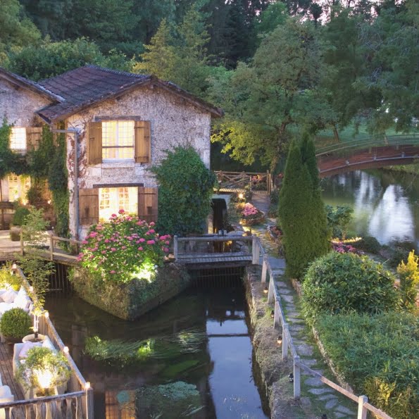 Hôtel Moulin du Roc vue de loin avec la rivière et les lumières allumées