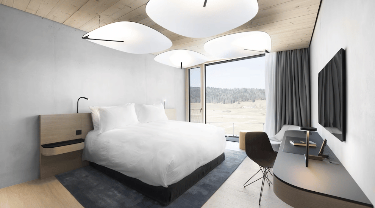 Lit double face á une télévision acroché au mur dans une chambre avec vue