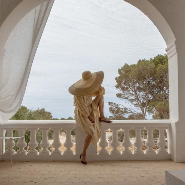 femme avec chapeau sur un balcon d'une chambre - hotel minorque