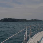 L'avant d'un voilier avec la mer et des colines en fond
