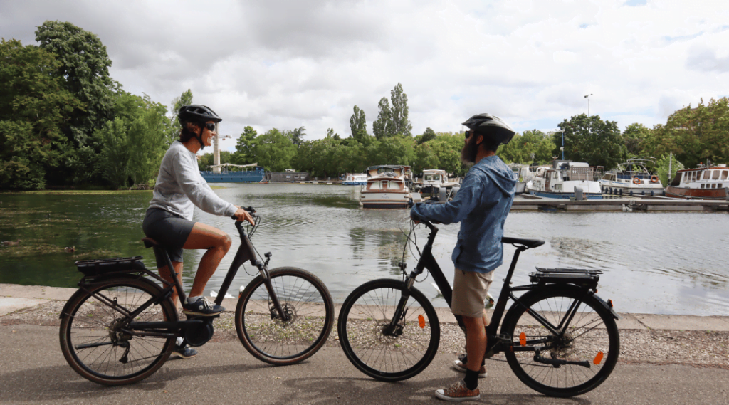 Deux personnes qui font du vélos au bord d'une rivière