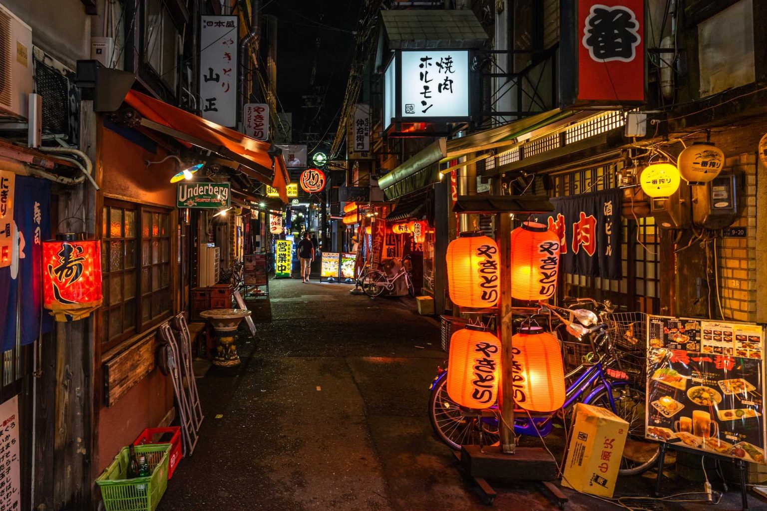 Osaka, Japan, August 2019 â€“ Night view of a quiet street in Osaka near Dotonbori area full of traditional japanese restaurants and colorful lanterns